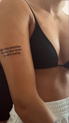 a woman with a tattoo on her arm that reads, every question is another word is saying