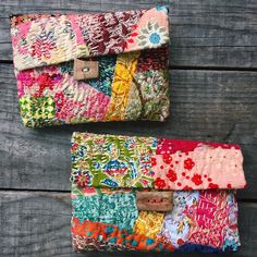 two multicolored purses sitting on top of a wooden table