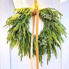 a green wreath hanging on the side of a building