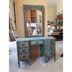 an old desk with a mirror on it in a room filled with furniture and other items