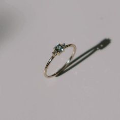 a diamond ring sitting on top of a white table next to a shadow cast object