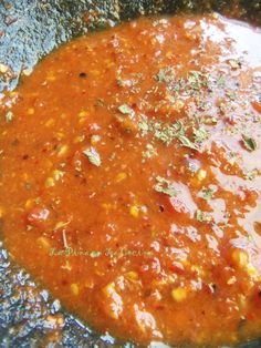 a pan filled with red sauce and vegetables