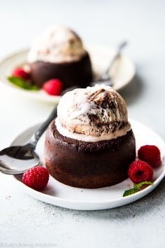 two desserts with ice cream and raspberries on a plate