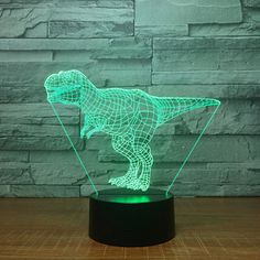 a green dinosaur lamp sitting on top of a wooden table