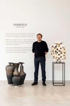 a man standing in front of some vases