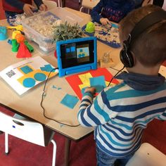 a young boy wearing headphones sitting at a table