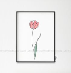 a drawing of two pink flowers in a black frame on a white wall next to a plant