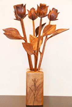 a wooden vase with flowers in it on a table