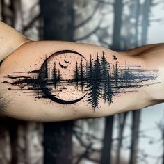 a man's arm with trees and a half moon tattoo on the left forearm