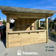 there is a small wooden bar on top of the roof and people are standing around it