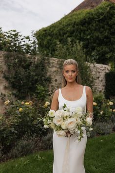 a woman in a wedding dress holding a bouquet