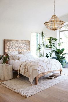 a bedroom with a bed, rug and plants in the corner on the wall next to it