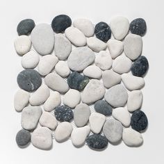 a white and black stone mosaic on a white surface with small rocks in the middle