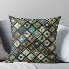 a decorative pillow on a couch with pillows and throw pillows in the shape of squares