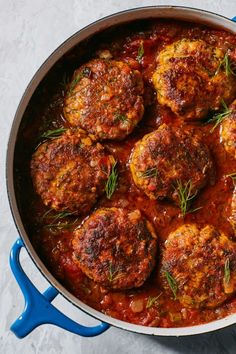 meatballs with tomato sauce and fresh herbs in a pan