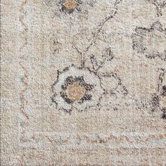 an area rug with floral designs on the top and bottom, is shown in beige tones