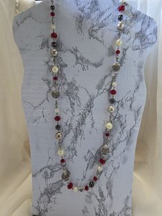 Add a touch of elegance to any outfit with this stunning vintage necklace from Premier Designs. The 36-inch beaded wrap features a beautiful combination of red and black imitation pearls, creating a unique and eye-catching look. The necklace is perfect for any occasion and can be stacked for added impact. Crafted from a mix of metals and glass, this necklace is both durable and stylish. The lobster closure ensures a secure fit, while the ball/bead chain type adds a touch of sophistication. This necklace is a true statement piece, with its art deco and retro theme making it a must-have for any fashion-forward woman. Wrap Necklace, Wrap Necklaces, Crown Design, Retro Theme, Premier Designs, Beaded Wraps, Bead Chain, Beaded Chain, Red And Black