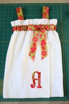 a white towel with red flowers on it and a green cutting board next to it