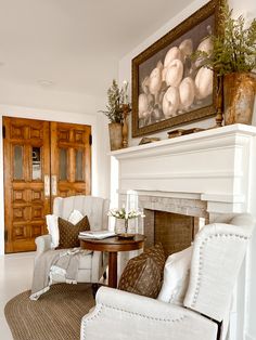 a living room filled with furniture and a painting on the wall over a fire place