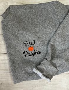 Hello Pumpkin Embroidered Sweatshirt MATERIAL: -Gildan Heavy Blend -50/50 Cotton/Polyester -Unisex Crewneck Sweatshirt SIZE AND FIT: -Sizes are unisex sizes from S - 3x (If you need a different size than listed please message me before purchasing so I can see if I can get you what you need) -Please see photo for the fit chart -For an oversize fit, size up 2 sizes CARE:  -Machine wash cold -Tumble dry low or hang dry PERSONALIZATION AVAILABLE: -If you wish to have the color of the threads changed, please message before purchasing, I am more than happy to embroider in the colors you'd like at no extra charge! PROCESSING: -Your new sweatshirt is made to order  -Please allow 1-2 weeks processing time  -Tracking number is provided when your order has been shipped Gray Fall Hoodie With Embroidered Logo, Gray Hoodie With Embroidered Logo For Fall, Gray Embroidered Logo Hoodie For Fall, Casual Embroidered Fall T-shirt, Casual Embroidered T-shirt For Fall, Fall Fleece Top With Embroidered Graphics, Black Fall Sweater With Embroidered Text, Black Sweater With Embroidered Text For Fall, Black Embroidered Text Sweater For Fall