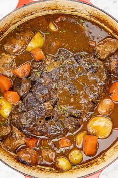 a pot filled with stew and vegetables on top of a table