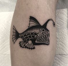 a black and white fish tattoo on the leg