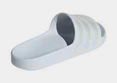 the adidas slipper in white is shown from the side, and has three stripes on