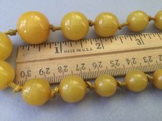 "Lovely egg yolk Bakelite single strand necklace. Hand tied graduated beads. Romantic, yellow necklace. Hidden bead clasp. Simply beautiful, gleaming, set of beads. Large knot, hand tied 1930s style. Chunky! Graduated beads: 8mm (smallest) to 17mm (largest) 15 1/2\" necklace Attention: All items are listed to the best of our observation, but they are pre-owned and pre-loved (meaning we may have missed something minor and/or be in need of light cleaning.) Please read our shop policies and/or conv 1930s Style, 2 Necklace, Yellow Necklace, 1930s Fashion, Egg Yolk, Gold Hands, Freshwater Pearl Necklaces, Strand Necklace, Simply Beautiful