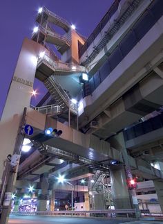 a very tall building with some lights on it's sides and stairs going up to the top