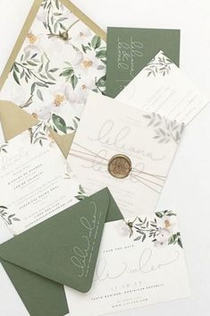 the wedding stationery is laid out on top of each other, including two envelopes and