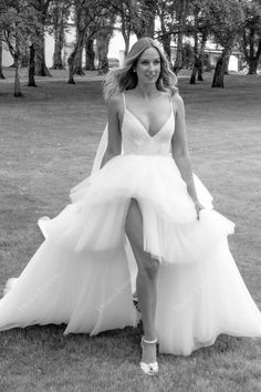 a woman in a white dress posing on the grass with her legs spread out and one leg