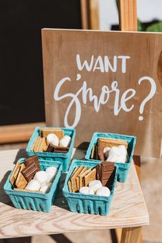 three blue baskets filled with marshmallows sitting on top of a wooden table