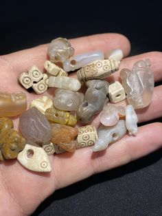 a hand is full of different types of rocks and stones that are being held in the palm