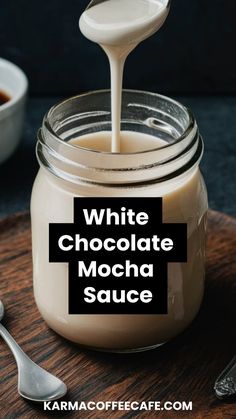 white chocolate mocha sauce being poured into a glass jar with spoons next to it