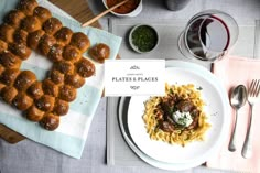 a white plate topped with pasta and meatballs next to a glass of red wine