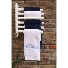 towels hanging on a towel rack in front of a brick wall