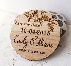 a wooden save the date magnet with flowers on it