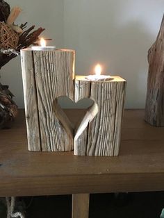 two candles are placed next to each other in the shape of a heart on a table