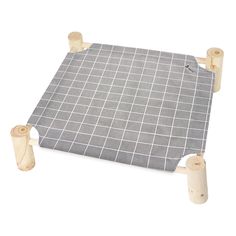 a gray and white checkered table mat with two wooden pegs next to it