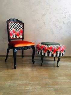 two chairs and a table in front of a wall with checkerboard designs on it