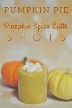 pumpkin spice latte shots with whipped cream on top and two mini pumpkins in the background