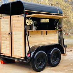 a small wooden trailer is parked in the dirt