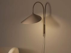 a lamp that is on the wall next to a chair