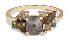 a yellow gold ring with brown and blue stones on the sides, surrounded by small diamonds