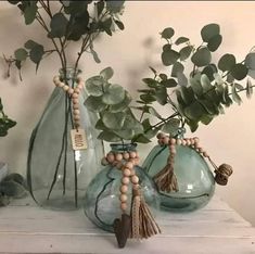 three vases with plants in them sitting on a table next to some other items