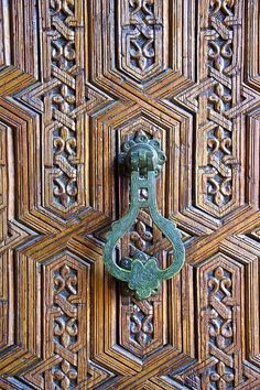 an ornate door handle on a wooden door