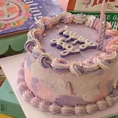 a birthday cake that is sitting on top of a book shelf next to some books