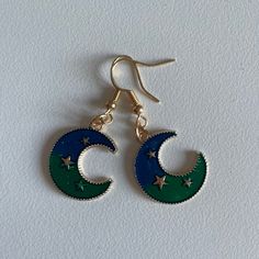 Celestial Collection Dangle Drop Earrings with a colourful Moon Charm and a slight Golden shine to it! Blue Crescent Earrings As A Gift, Celestial Half Moon Single Earring, Celestial Blue Pierced Earrings, Blue Celestial Pierced Earrings, Celestial Green Jewelry With Moon Charm, Celestial Blue Single Earring, Elegant Blue Earrings With Moon Charm, Blue Round Earrings With Moon Charm, Blue Celestial Round Earrings