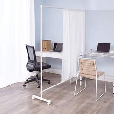 an office with two desks and a chair in front of a computer monitor on a stand