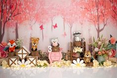 there are many stuffed animals on display in front of a wall with flowers and trees